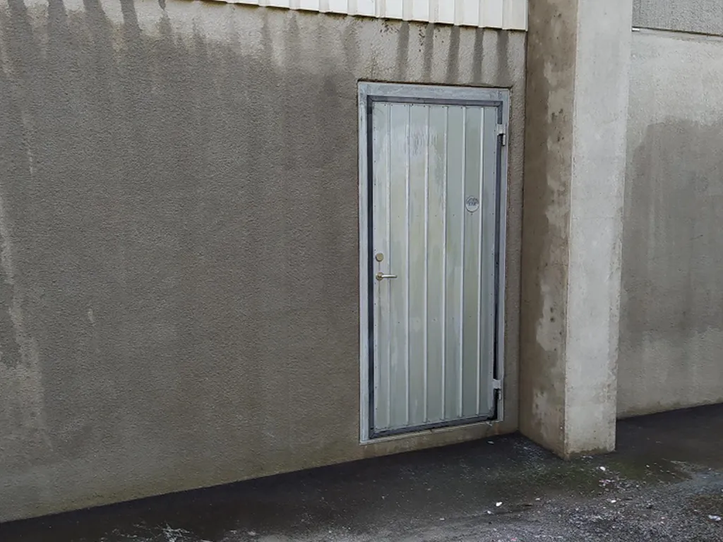 efterbild på betong samt plåtdörr efter utförd sanering av täckande graffiti